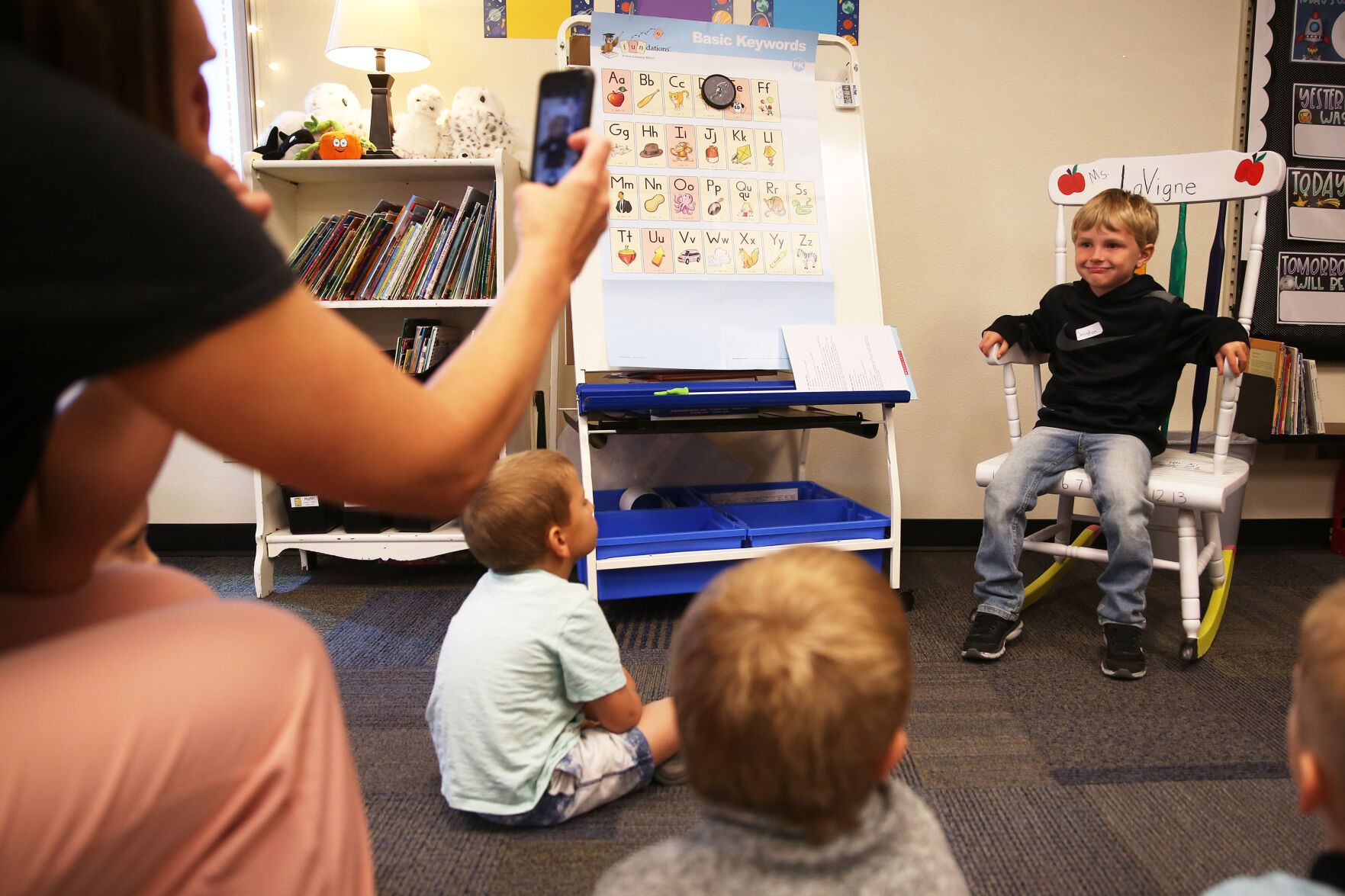 Christian Nelson sits in the rocking chair while his teacher Alicia LaVigne